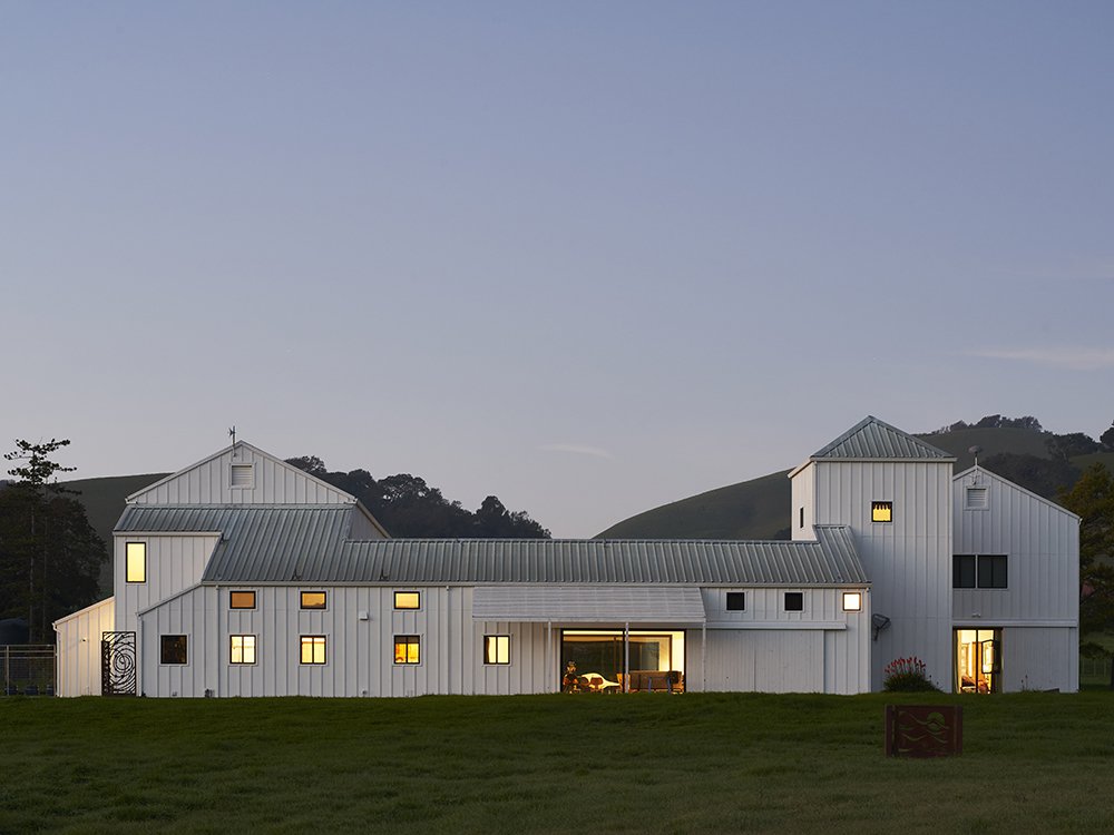 Eames Ranch exterior view surrounded by trees and hills in the background.