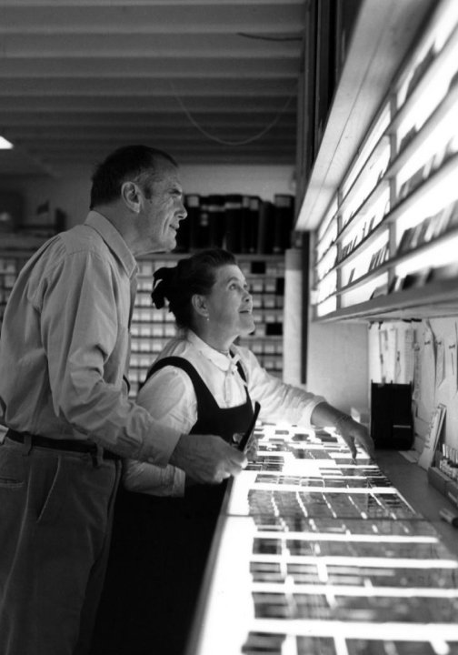 Ray and Charles Eames looking at images on a light box.