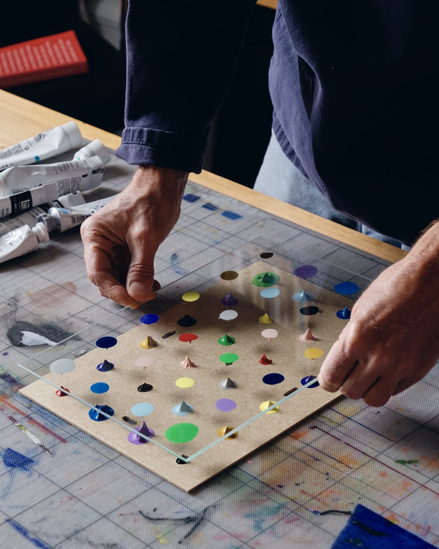 For Clip Frame Paintings, artist Daniel Eatock dabs paint, affixes the glass, adds more paint, and repositions the glass.