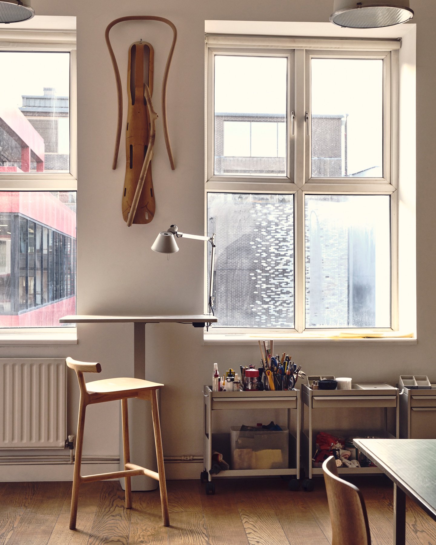 Small corner of design studio Industrial Facility featuring a work table, chair, and tools—Kazam! Magazine.
