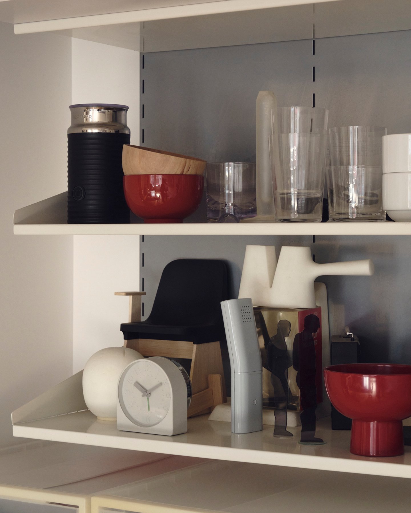 Shelves at design studio Industrial Facility featuring designs for objects such as a clock, knife sharpener, and bowl.