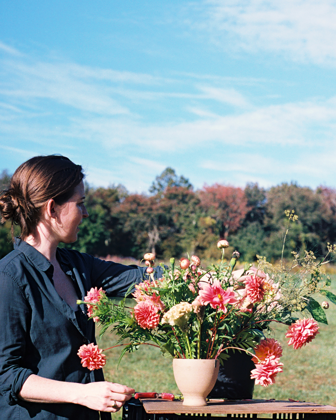 MASS Design Group's Caitlin Taylor tending to flowers at Four Root Farm in East Haddam, Connecticut.