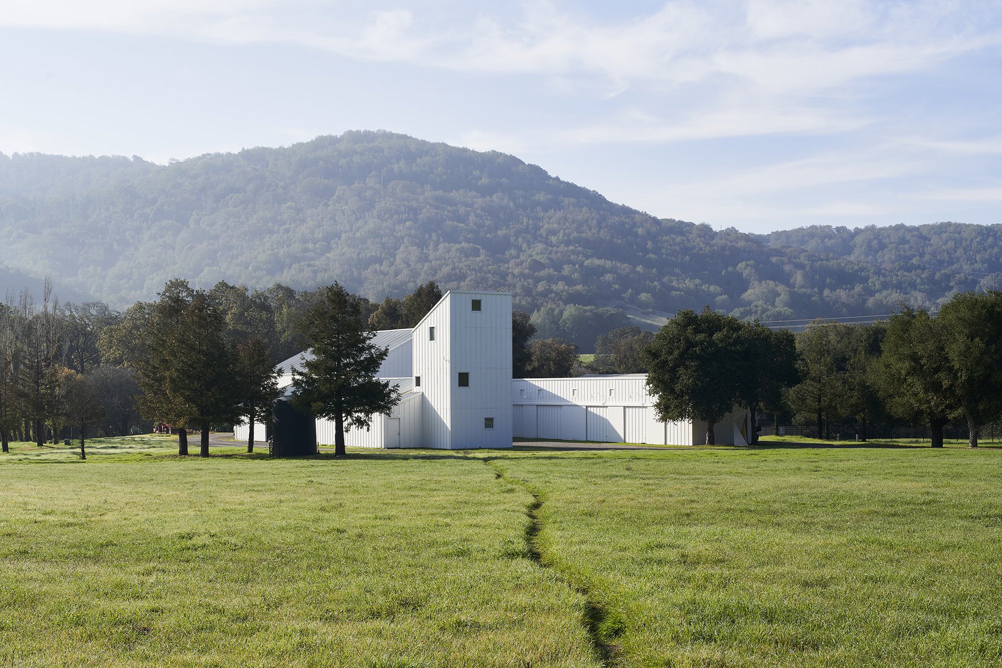 Eames Ranch exterior view surrounded by trees and hills in the background.