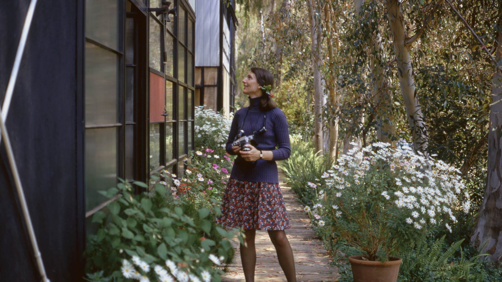 Lucia Eames as a young woman outside the Case Study House designed by Ray and Charles Eames, Kazam! Magazine.