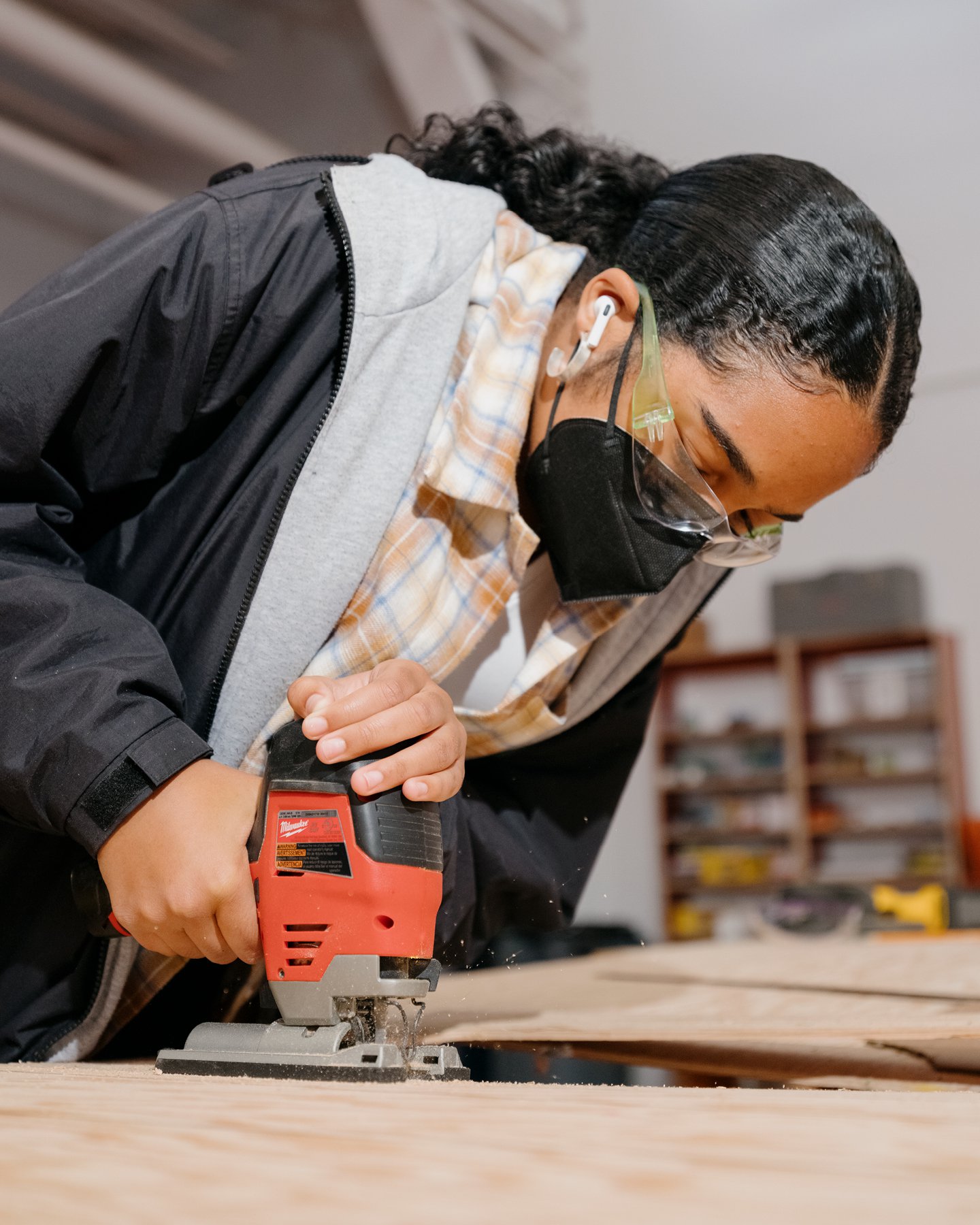 Girls Garage, a workshop and design/build program in Berkeley California, showing a student using tools at a work table.