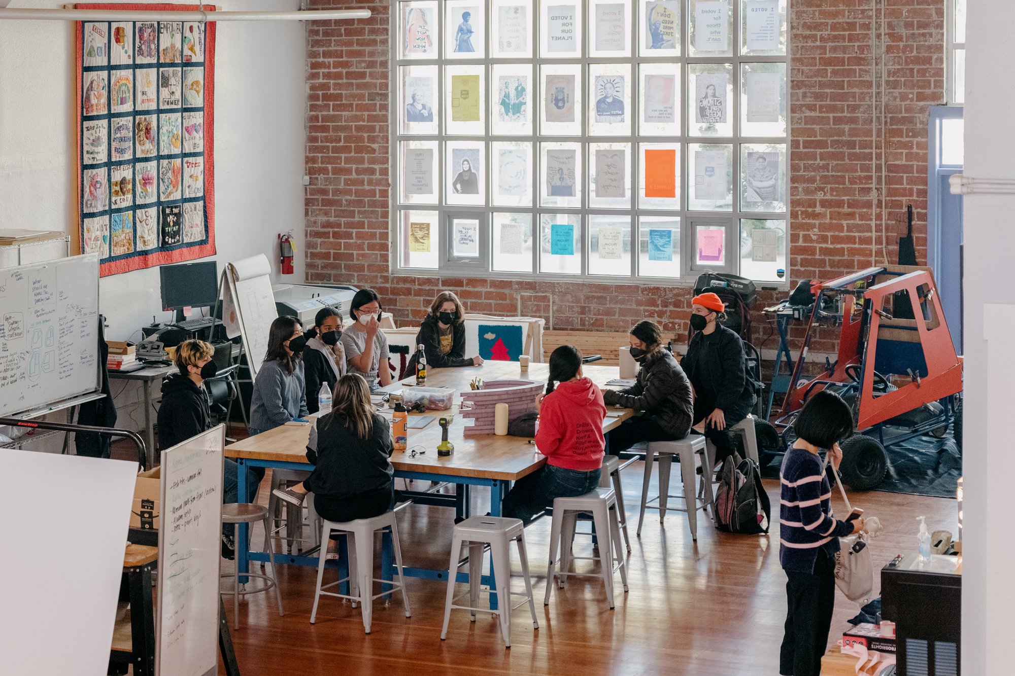 Girls Garage, a design/build workshop in Berkeley California with Emily Pilloton-Lam, founder and executive director sitting among her students in the workshop.
